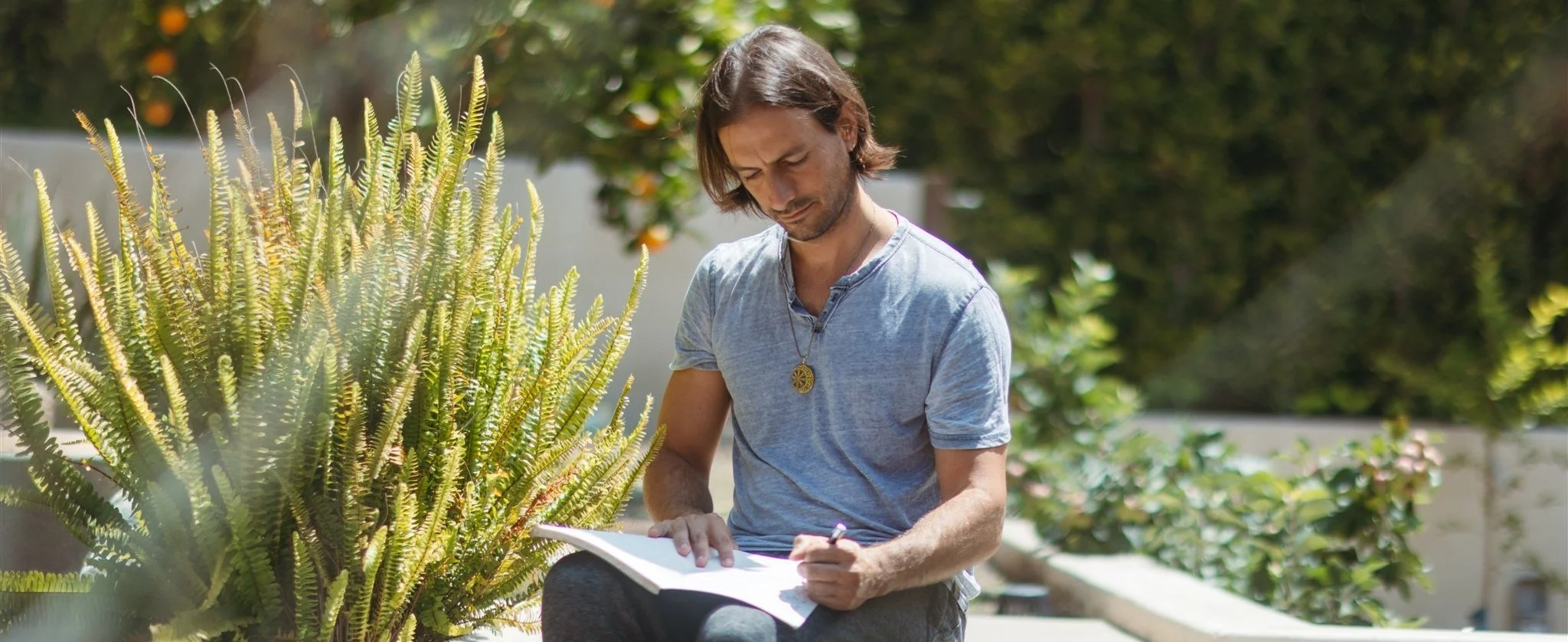 Iván Chocrón writing in a garden